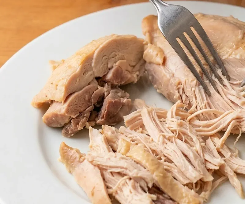 Shred warm chicken with two forks